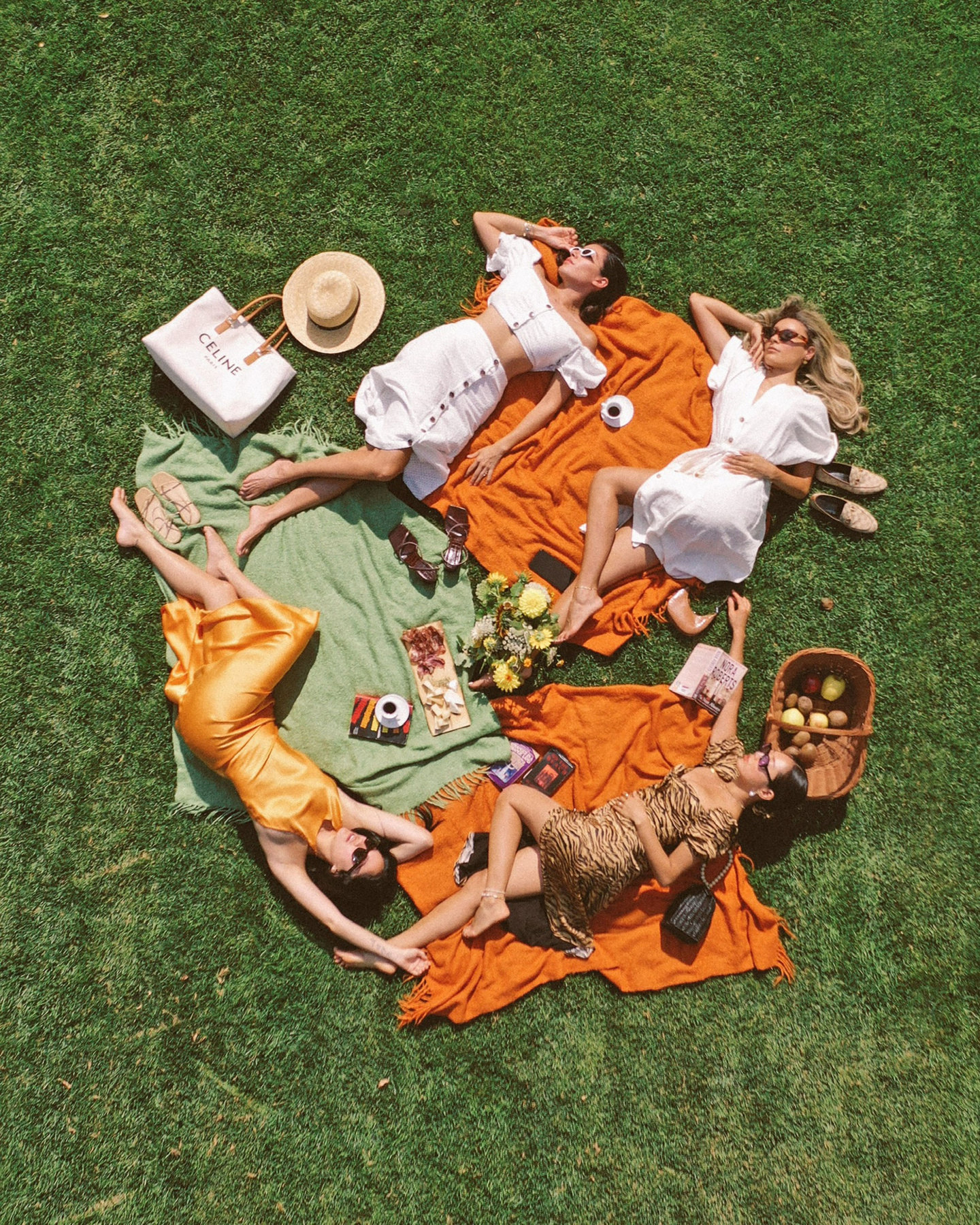 A group of friends lying on the grass outside in Forsyth Park