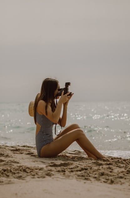 A woman taking pictures on the beach