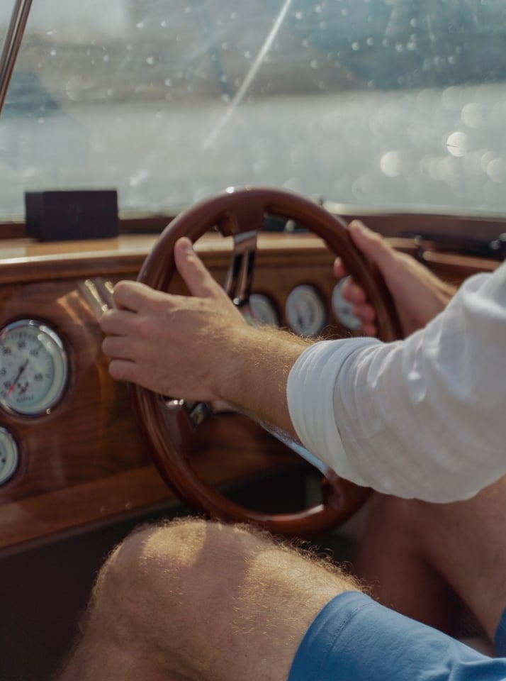 A man piloting a boat on the water