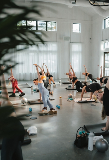 A group of people practicing yoga in a fitness room