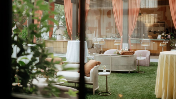 A meeting room with a bar, seating area, and grass floor