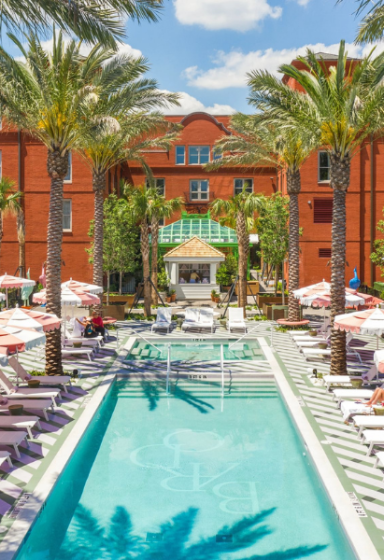 Aerial view of the Bardo outdoor pool surrounded by lounge chairs and palm trees
